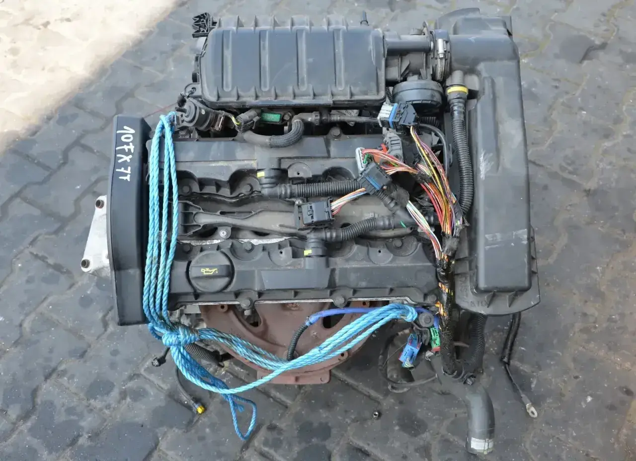 Silnik do Peugeot 307 1.6 benzyna, z widocznym kodem 107FX7T i niebieskimi linami.