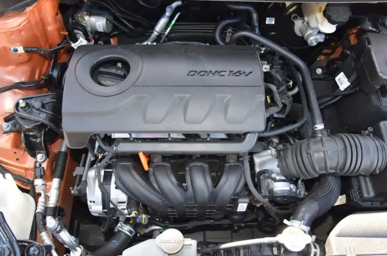 Silnik DOHC 16V 1.6 mpi w samochodzie, z widocznymi przewodami i elementami układu dolotowego.