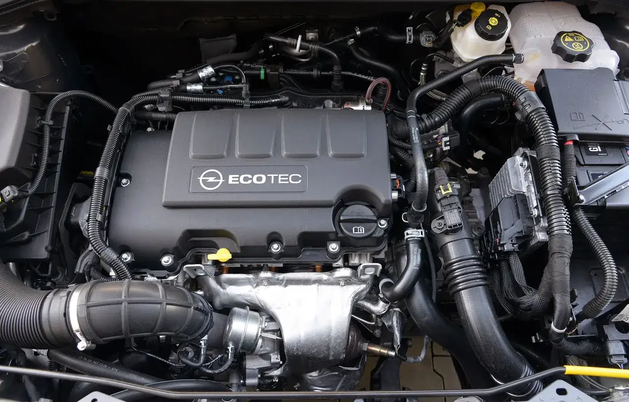 Silnik Opel Corsa D 1.4 benzyna. Widoczny pokrywa zaworów Ecotec, kolektor dolotowy i elementy układu chłodzenia.