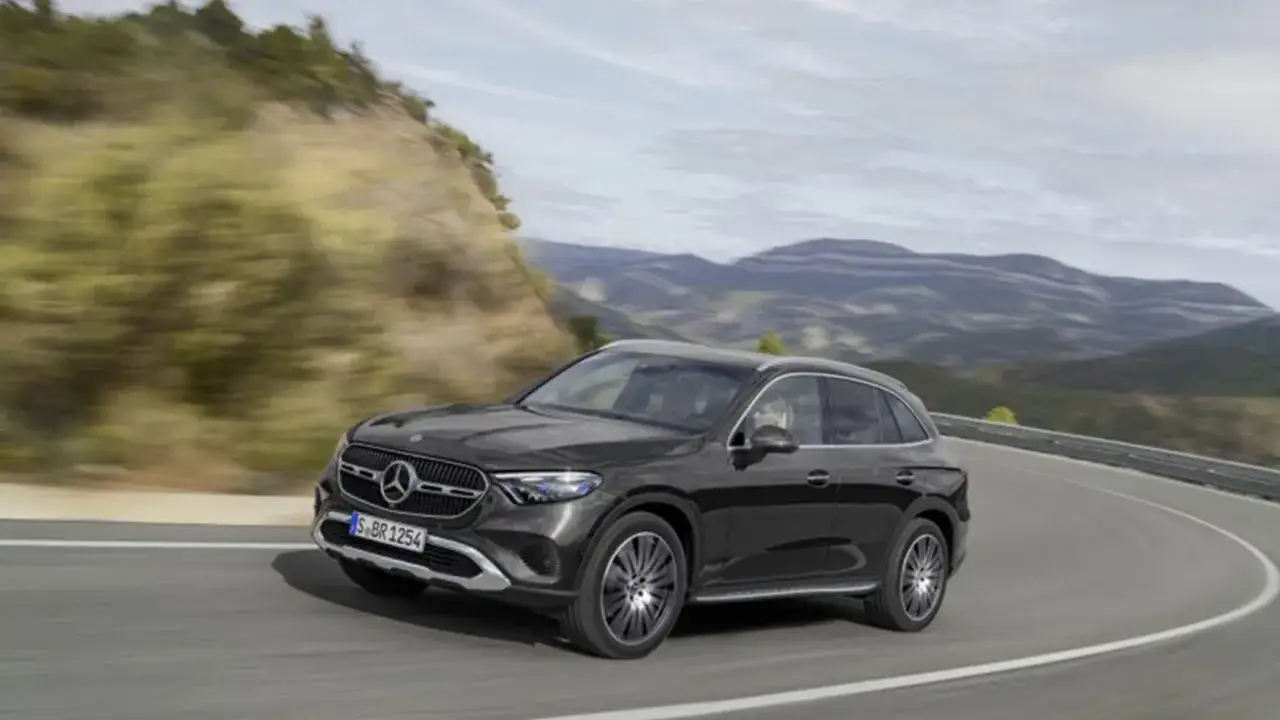 Ciemny Mercedes GLC 200 pokonuje zakręt na malowniczej górskiej drodze, ukazując swoją dynamikę i elegancję.