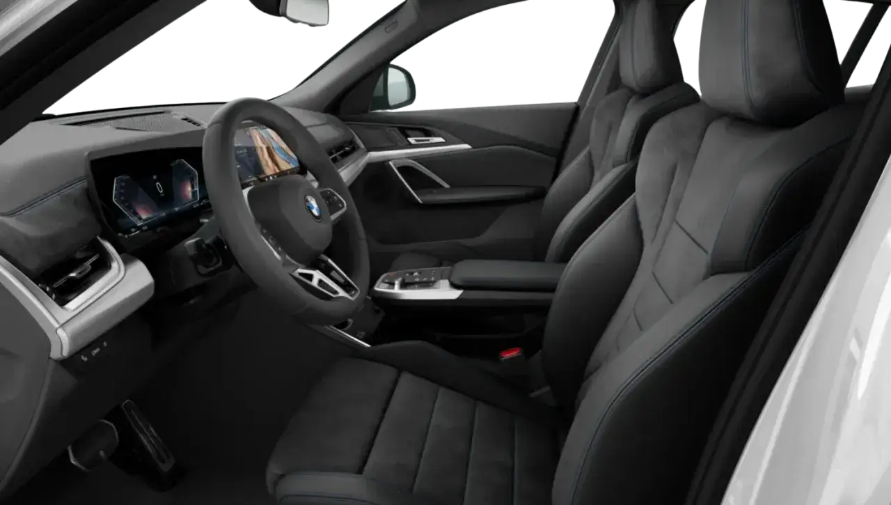 Wnętrze BMW X2 2025: sportowe fotele z niebieskimi przeszyciami, nowoczesny kokpit z dużymi ekranami i kierownicą.