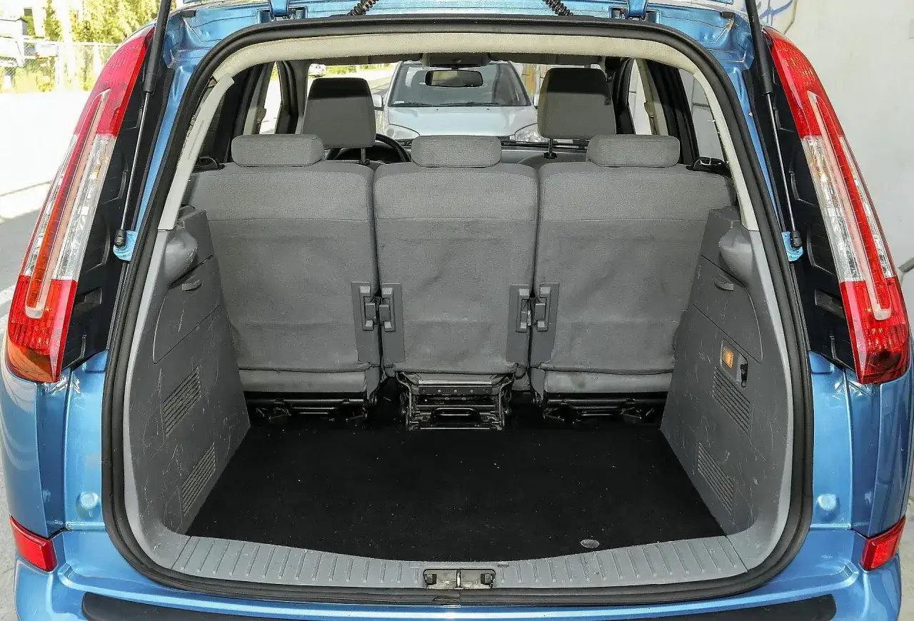 Błękitny Ford C-Max 1.6 TDCI z otwartym bagażnikiem. Widoczne tylne siedzenia i czarna wykładzina bagażnika.
