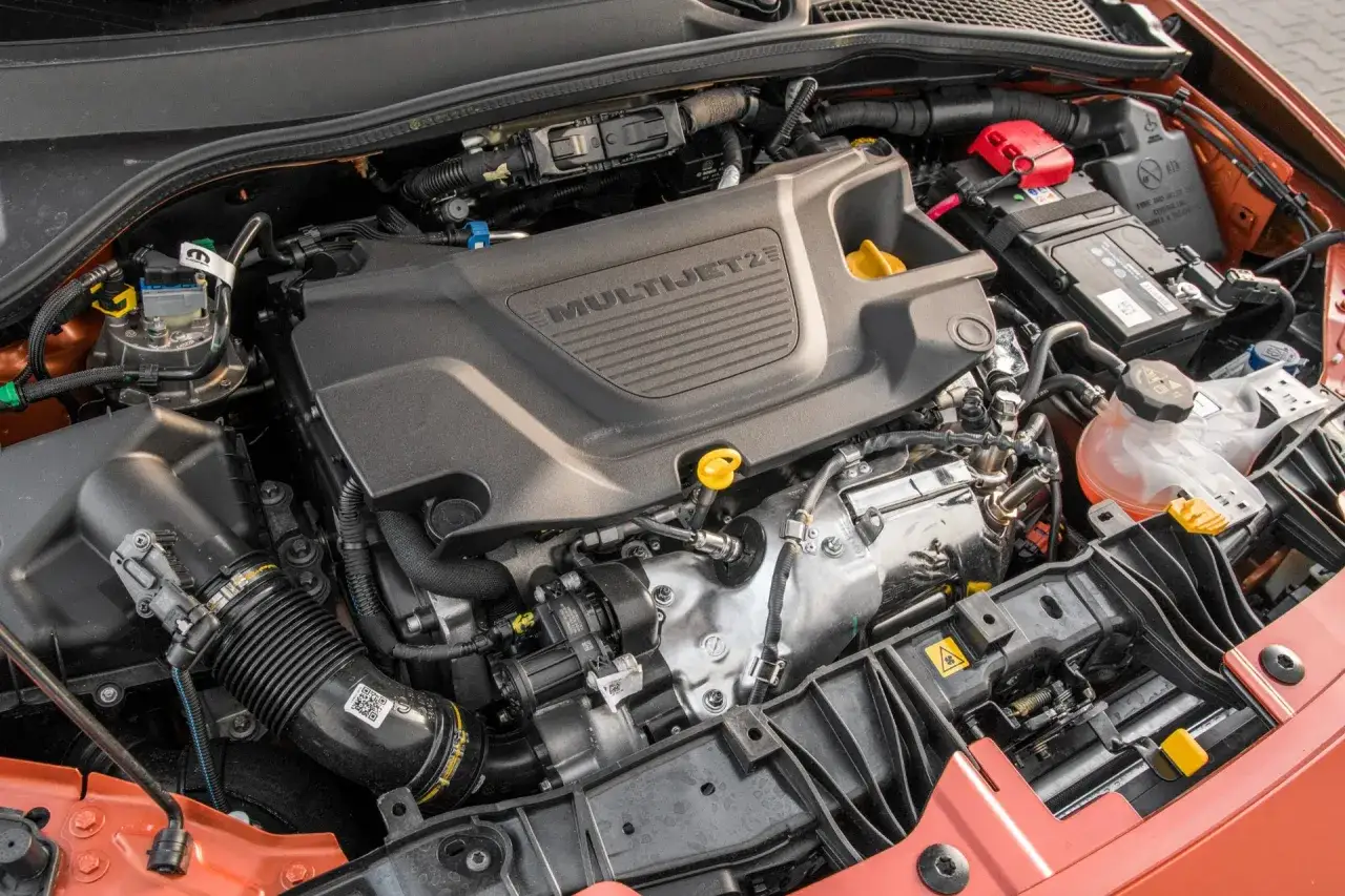 Silnik MultiJet2 w Fiat Tipo 1.4. Widok z góry na elementy pod maską, w tym akumulator i układ dolotowy.