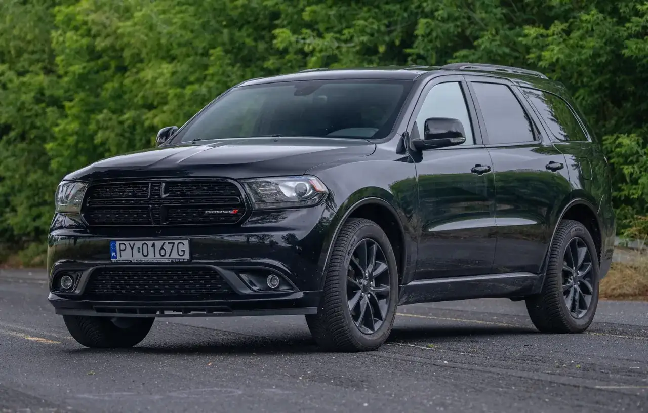 Czarny Dodge Durango 3.6, lśniący na tle zieleni. Ten SUV to idealny kompan na każdą drogę.
