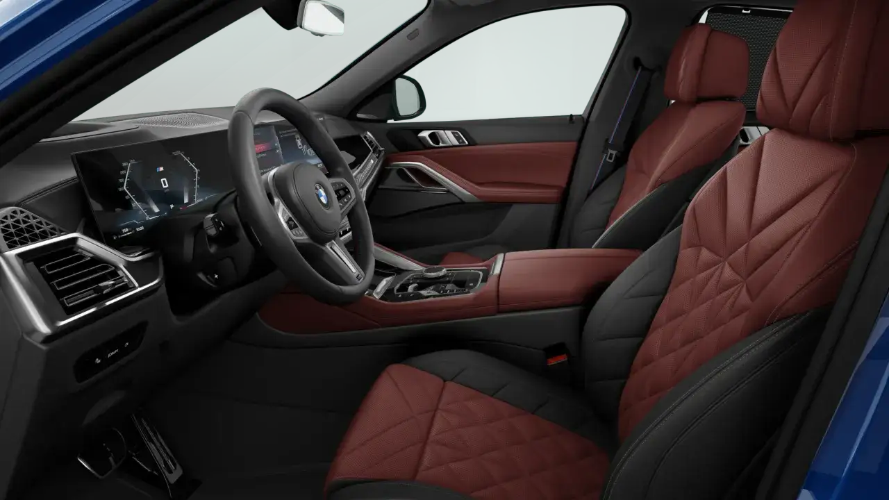 Wnętrze BMW X6 z czerwono-czarną skórzaną tapicerką. Cyfrowy kokpit i kierownica. Sprawdź BMW X6 cena!